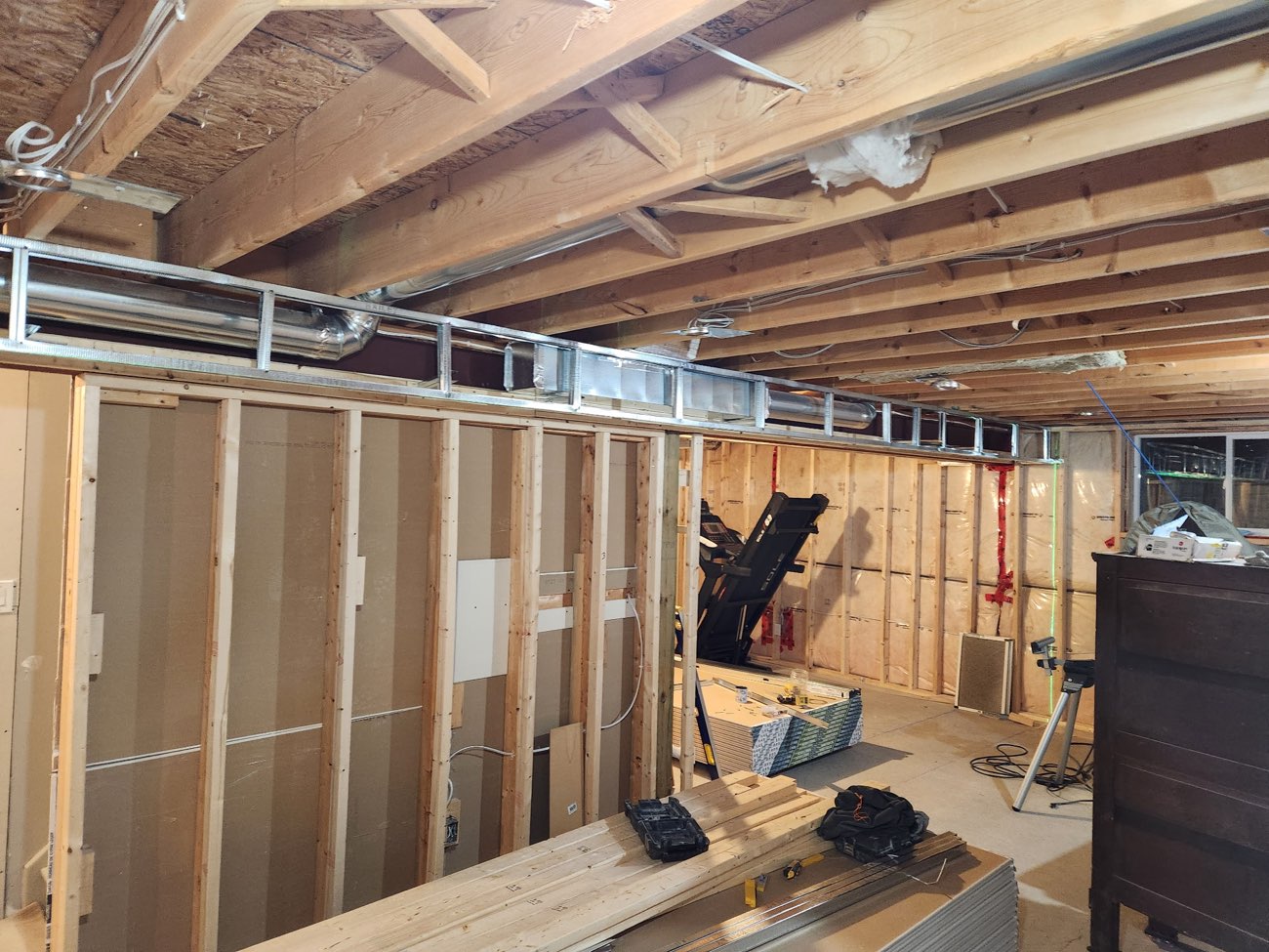 Basement wall framing with steel resilient channel along the ceiling line